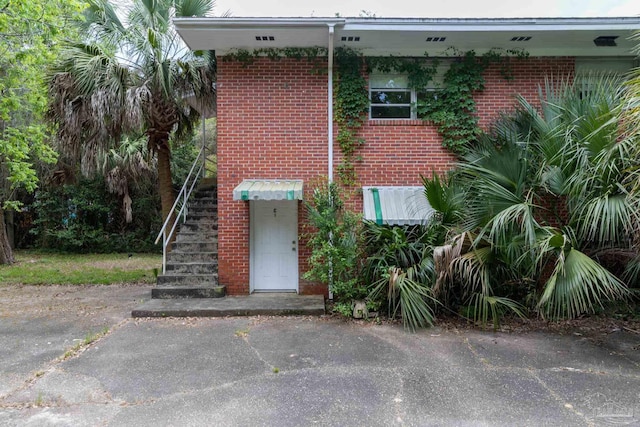 view of front of home with stairs and brick siding