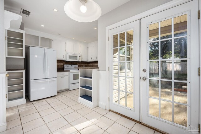 kitchen with white appliances, backsplash, french doors, white cabinets, and light tile patterned flooring