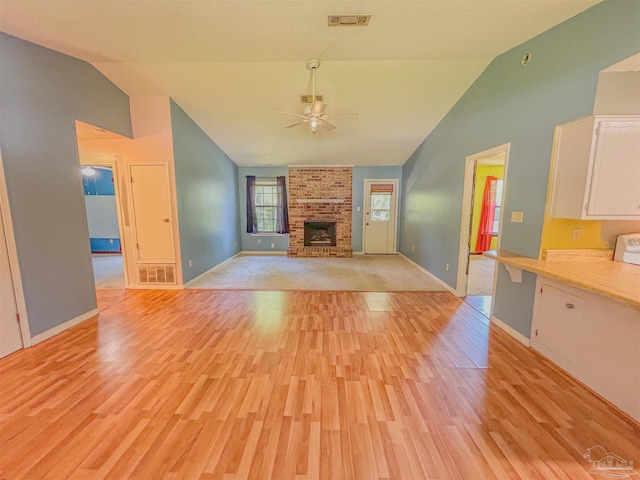 unfurnished living room featuring a ceiling fan, visible vents, light wood-style flooring, and baseboards