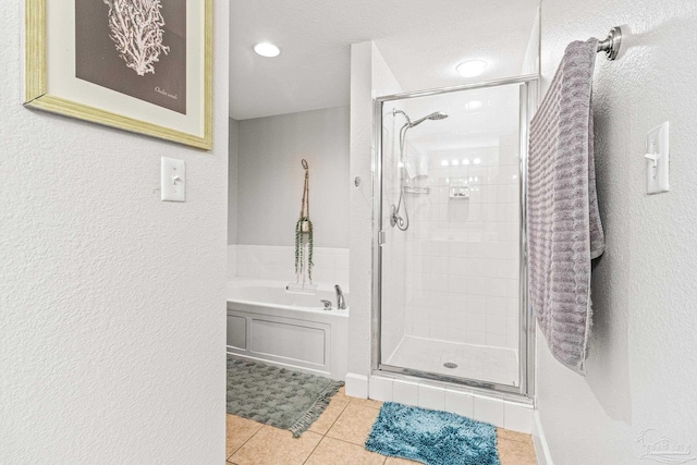 bathroom with a textured ceiling, shower with separate bathtub, and tile patterned flooring