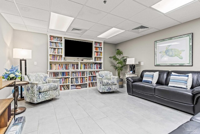 tiled living room with a paneled ceiling