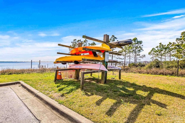 surrounding community featuring a lawn and a water view