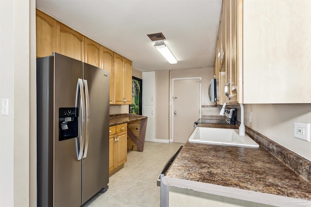 kitchen with light tile patterned flooring, sink, and stainless steel appliances