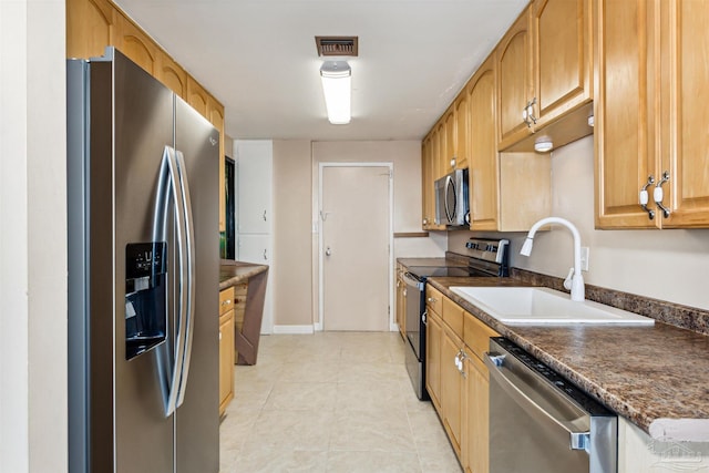 kitchen featuring light tile patterned floors, stainless steel appliances, and sink