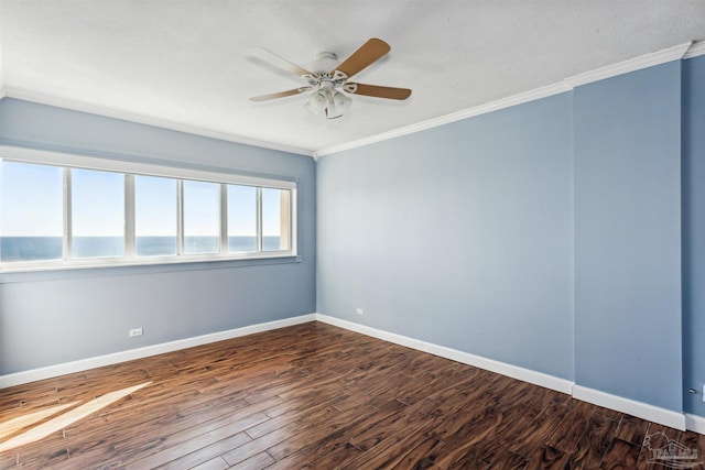 empty room featuring ceiling fan, crown molding, and dark wood-type flooring