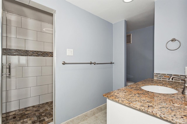 bathroom with walk in shower, vanity, and toilet