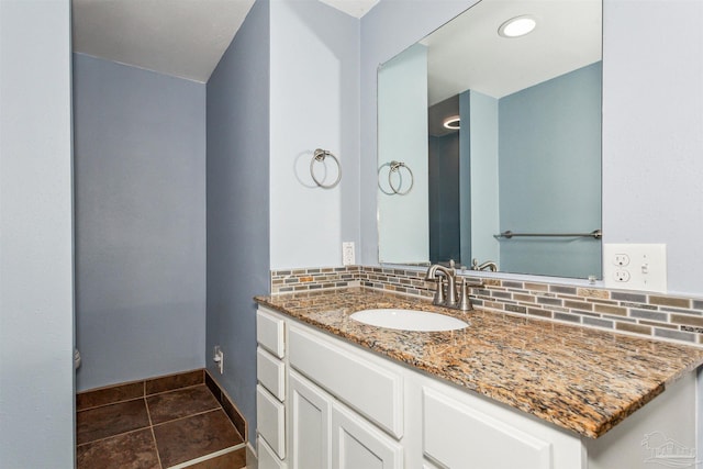 bathroom featuring tile patterned flooring, vanity, and backsplash