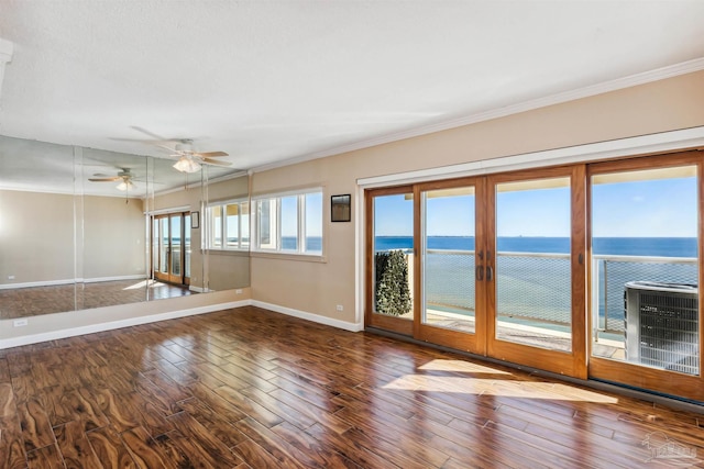 spare room featuring ceiling fan, a water view, ornamental molding, and hardwood / wood-style flooring