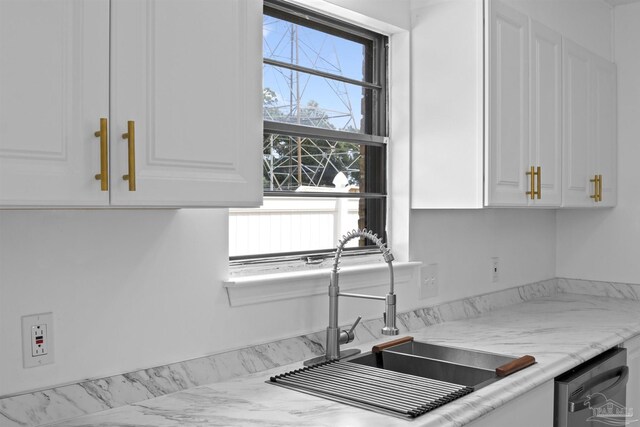 kitchen featuring white cabinetry, dishwasher, and a sink