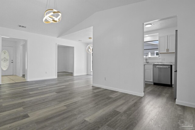 unfurnished living room with visible vents, baseboards, lofted ceiling, wood finished floors, and a textured ceiling