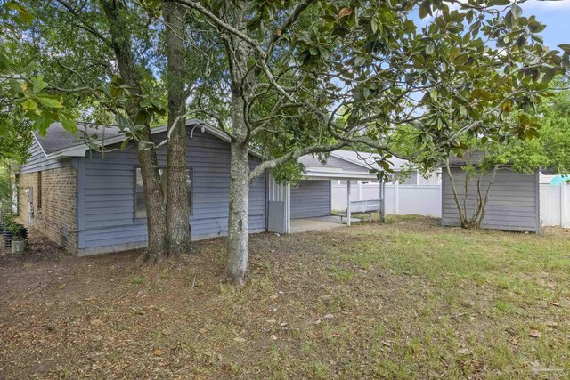 view of yard featuring an outdoor structure and fence