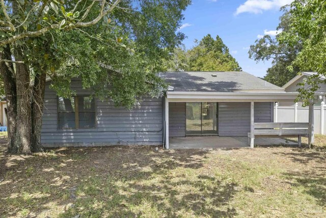 rear view of house with a patio and fence