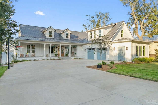 view of front of house featuring a front lawn, covered porch, and a garage