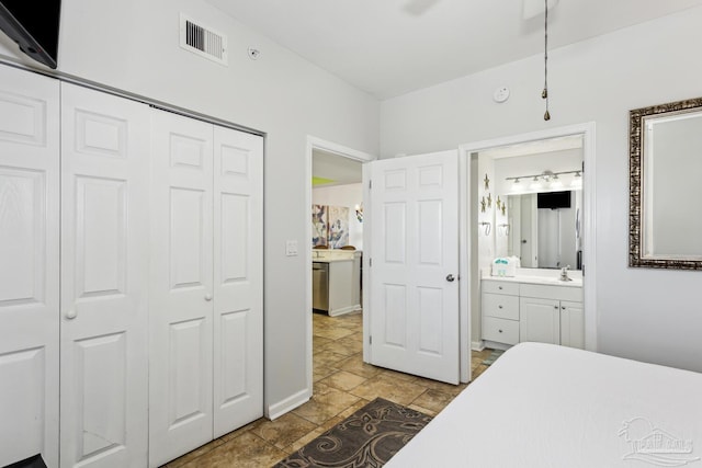 bedroom with sink, ensuite bath, a closet, and ceiling fan