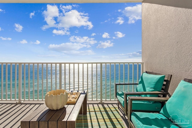 balcony featuring a water view and a view of the beach