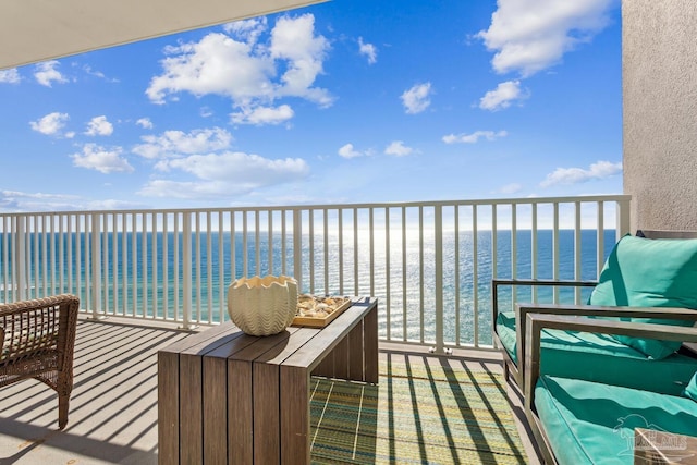 balcony with a water view and a view of the beach