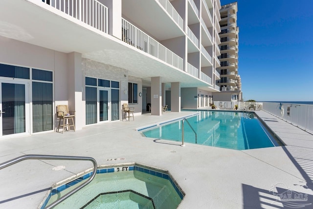 view of swimming pool with a patio and a hot tub