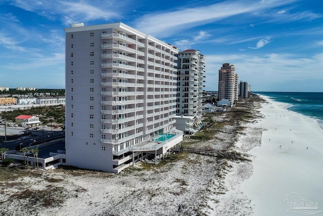 view of building exterior featuring a water view and a view of the beach