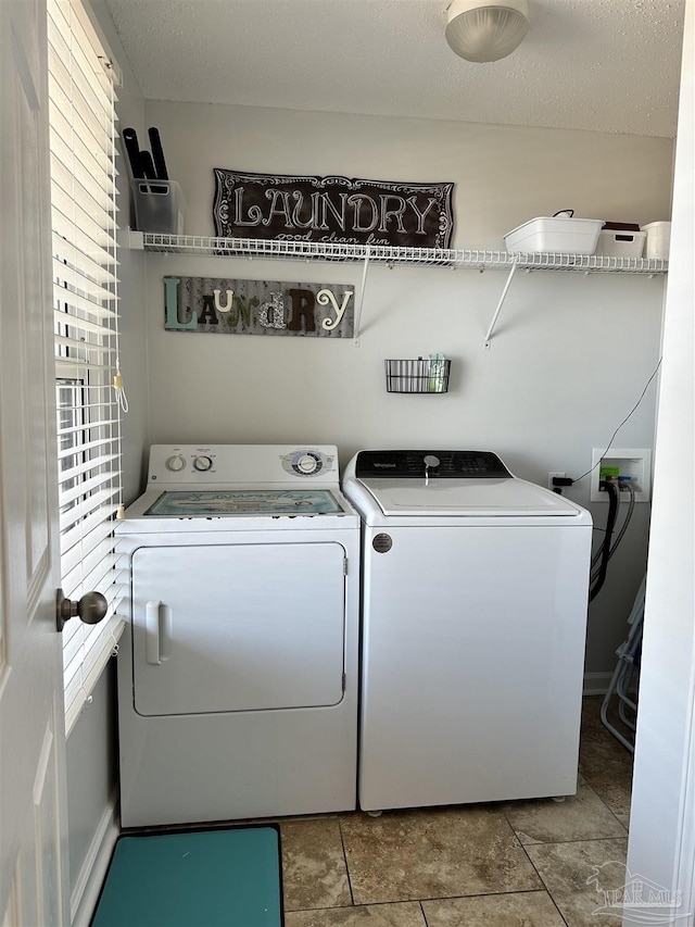 laundry room with washer and dryer and a textured ceiling