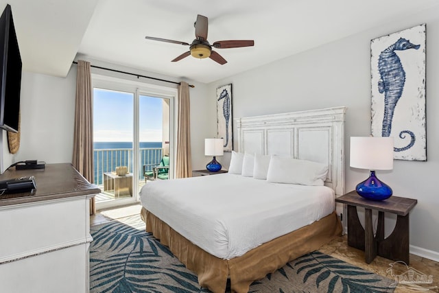 bedroom with access to exterior, ceiling fan, and a water view