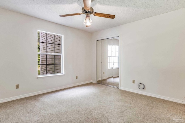 empty room featuring ceiling fan, carpet floors, and a textured ceiling