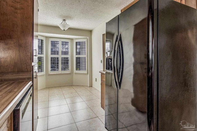 kitchen featuring light tile patterned flooring, a textured ceiling, and black refrigerator with ice dispenser