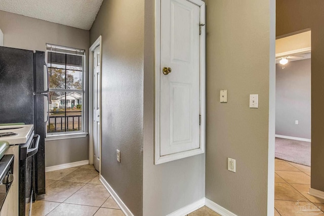 321 Loveland Cir, Pensacola, FL 32526 - kitchen with white range with electric cooktop, light tile patterned floors, freestanding refrigerator, baseboards, and a textured ceiling