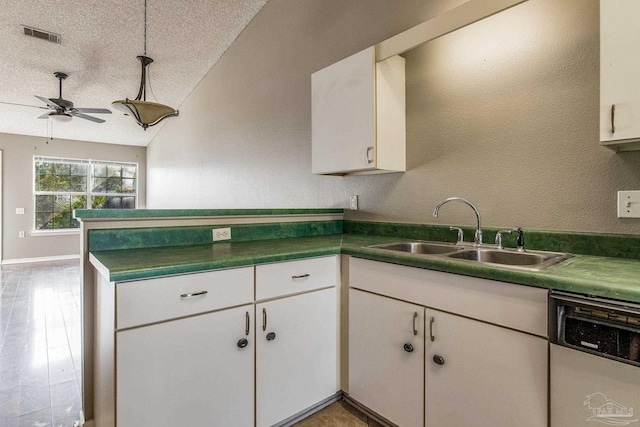 321 Loveland Cir, Pensacola, FL 32526 - kitchen with stainless steel dishwasher, a sink, a peninsula, white cabinetry, and ceiling fan