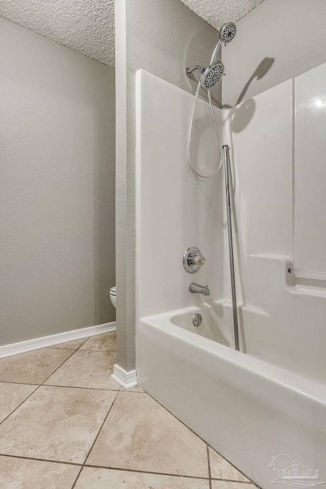 bathroom with toilet, a textured ceiling, tile patterned floors, and  shower combination