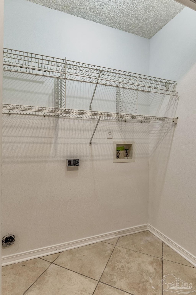 laundry area with washer hookup, a textured ceiling, and tile patterned floors