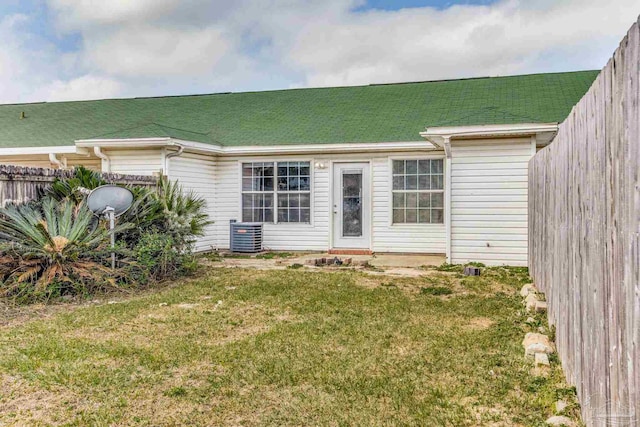 rear view of house featuring a yard and central AC