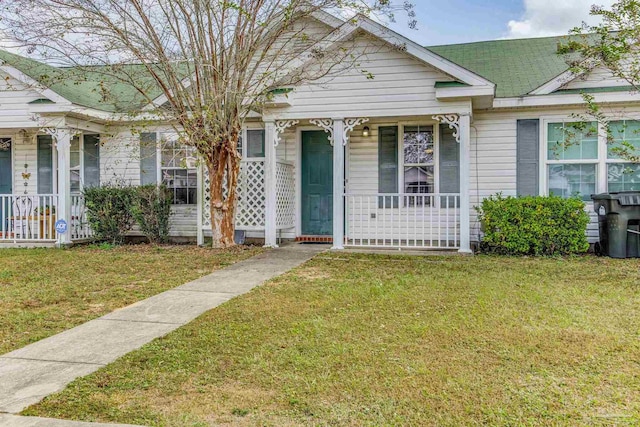 bungalow with covered porch and a front lawn