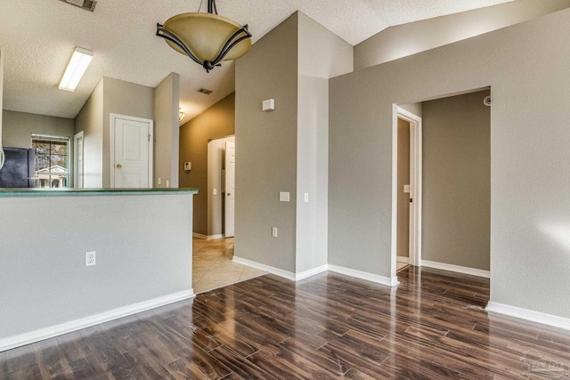 321 Loveland Cir, Pensacola, FL 32526 - empty room featuring vaulted ceiling, wood finished floors, a textured ceiling, and baseboards