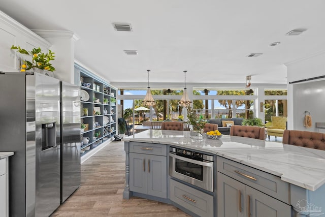 8209 Pompano St, Navarre, FL 32566 - kitchen featuring stainless steel fridge with ice dispenser, gray cabinetry, light wood-style floors, light stone counters, and pendant lighting
