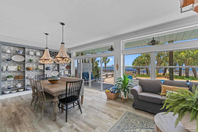 8209 Pompano St, Navarre, FL 32566 - dining area featuring light wood finished floors, crown molding, and a chandelier