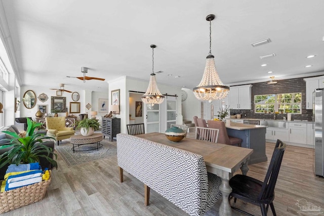 8209 Pompano St, Navarre, FL 32566 - dining area featuring a chandelier, light wood-type flooring, and recessed lighting