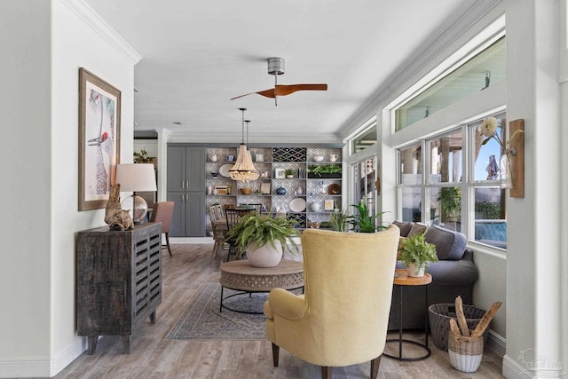 8209 Pompano St, Navarre, FL 32566 - living area with ornamental molding, wood finished floors, a ceiling fan, and healthy amount of natural light