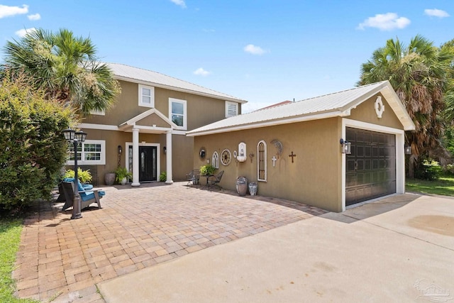 8209 Pompano St, Navarre, FL 32566 - back of property with stucco siding, a garage, a metal roof, and an outbuilding