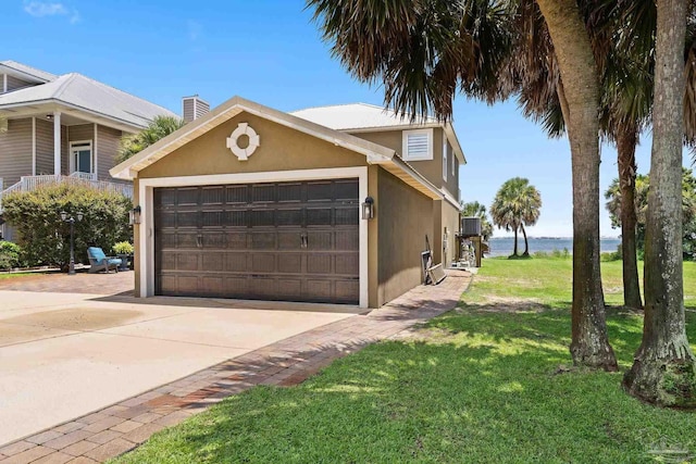 8209 Pompano St, Navarre, FL 32566 - view of side of home with stucco siding, a garage, a yard, a chimney, and driveway