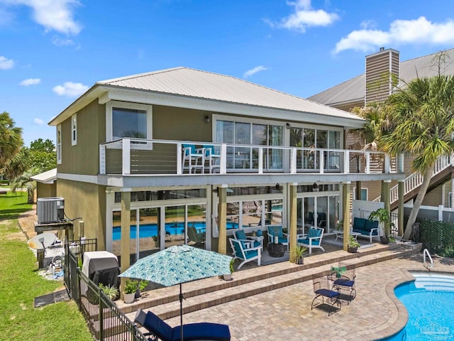 8209 Pompano St, Navarre, FL 32566 - back of house with a patio area, a metal roof, an outdoor pool, stairway, and a balcony