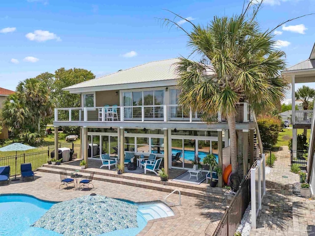 8209 Pompano St, Navarre, FL 32566 - rear view of property with a balcony, a patio, and a metal roof