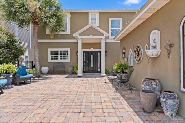 8209 Pompano St, Navarre, FL 32566 - entrance to property featuring a patio area and stucco siding