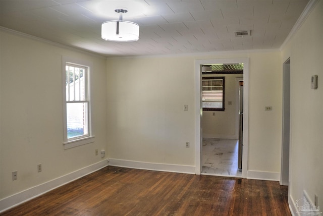 spare room featuring dark hardwood / wood-style flooring and crown molding