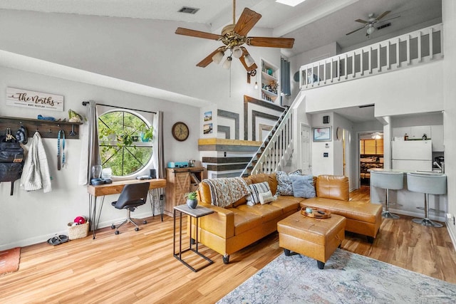 living room featuring ceiling fan, wood-type flooring, and high vaulted ceiling