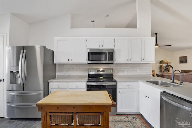 kitchen featuring appliances with stainless steel finishes, white cabinetry, and a sink