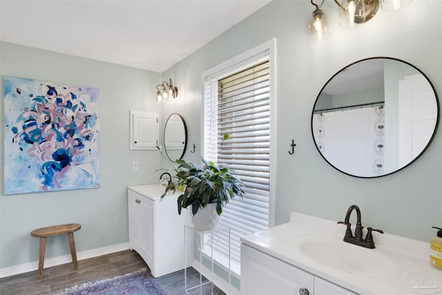 bathroom featuring vanity, baseboards, and wood finished floors