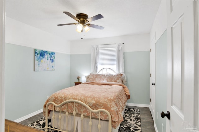 bedroom with dark wood-style floors, a ceiling fan, and baseboards