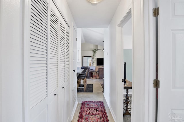 hall featuring lofted ceiling and light tile patterned floors