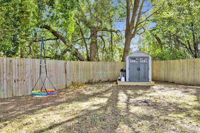 view of yard with a fenced backyard, an outdoor structure, and a storage unit