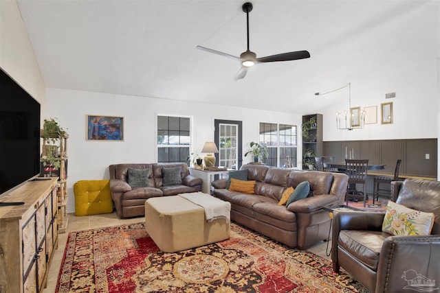 living room with ceiling fan with notable chandelier, visible vents, vaulted ceiling, and light tile patterned floors